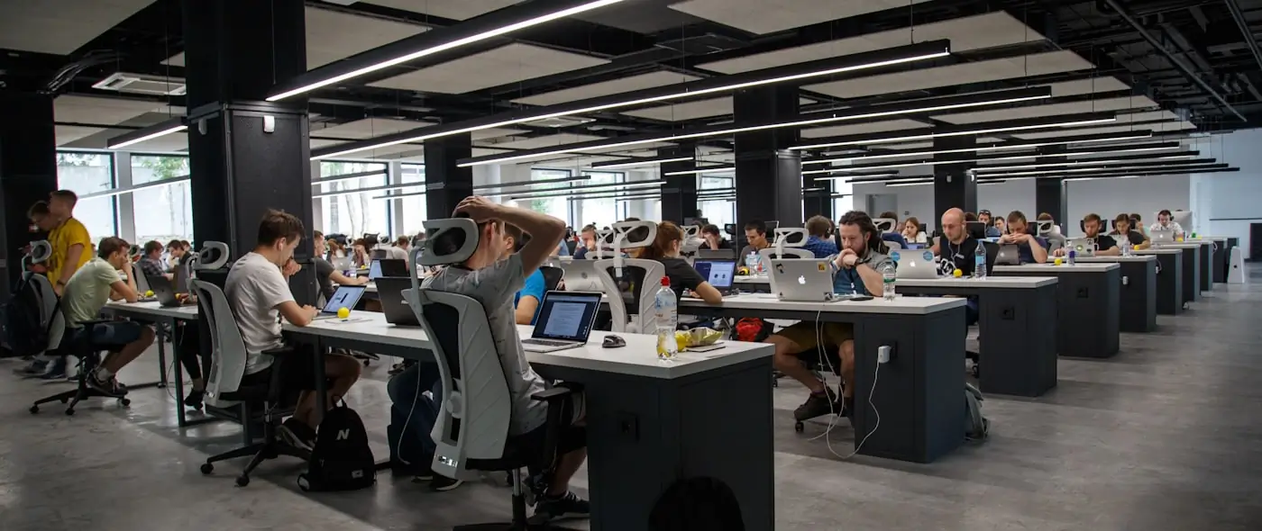 Busy modern workspace with multiple screens showing various applications and dashboards