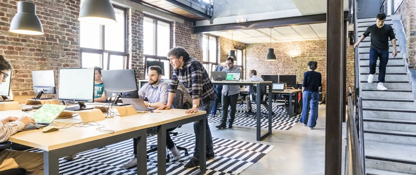 Team collaborating around laptops in a bright office space