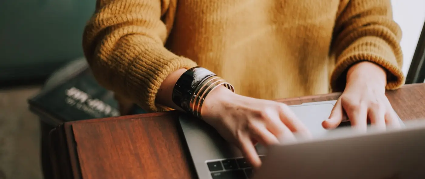 Person typing on a laptop during a client video call