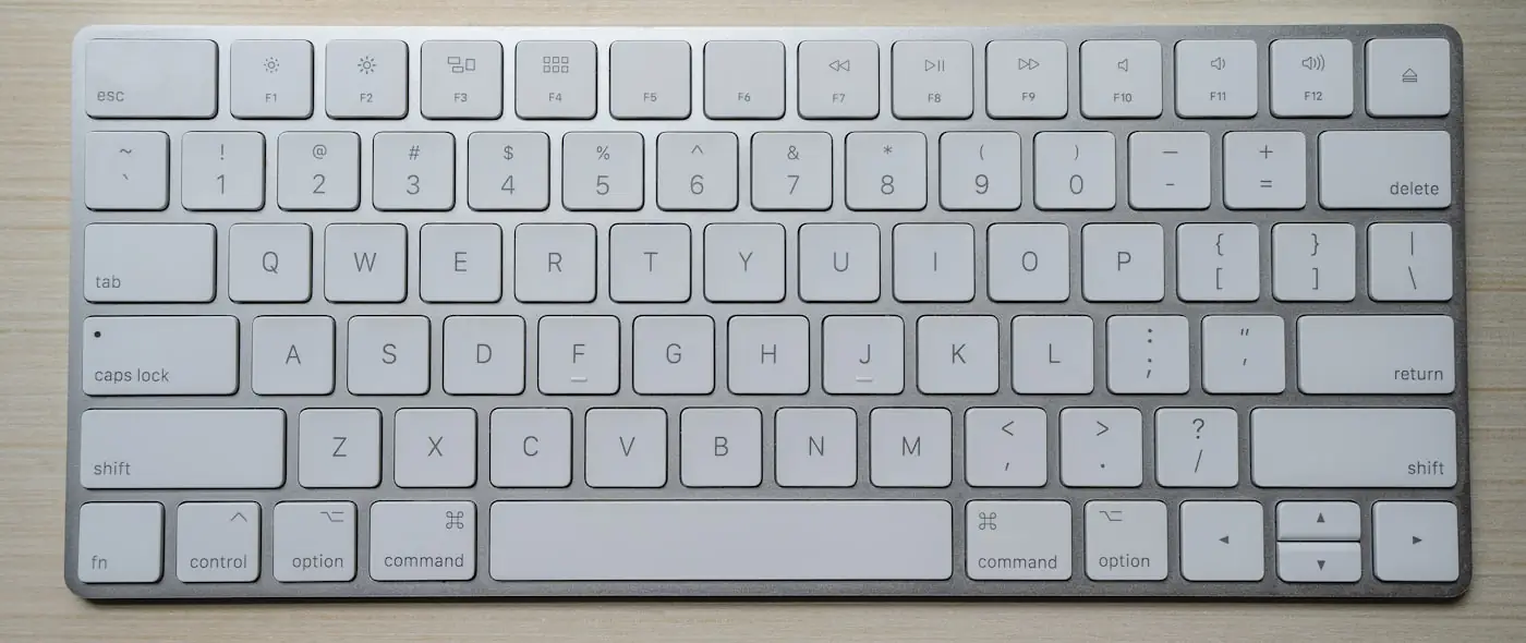 Close-up of hands typing on a sleek keyboard with warm lighting