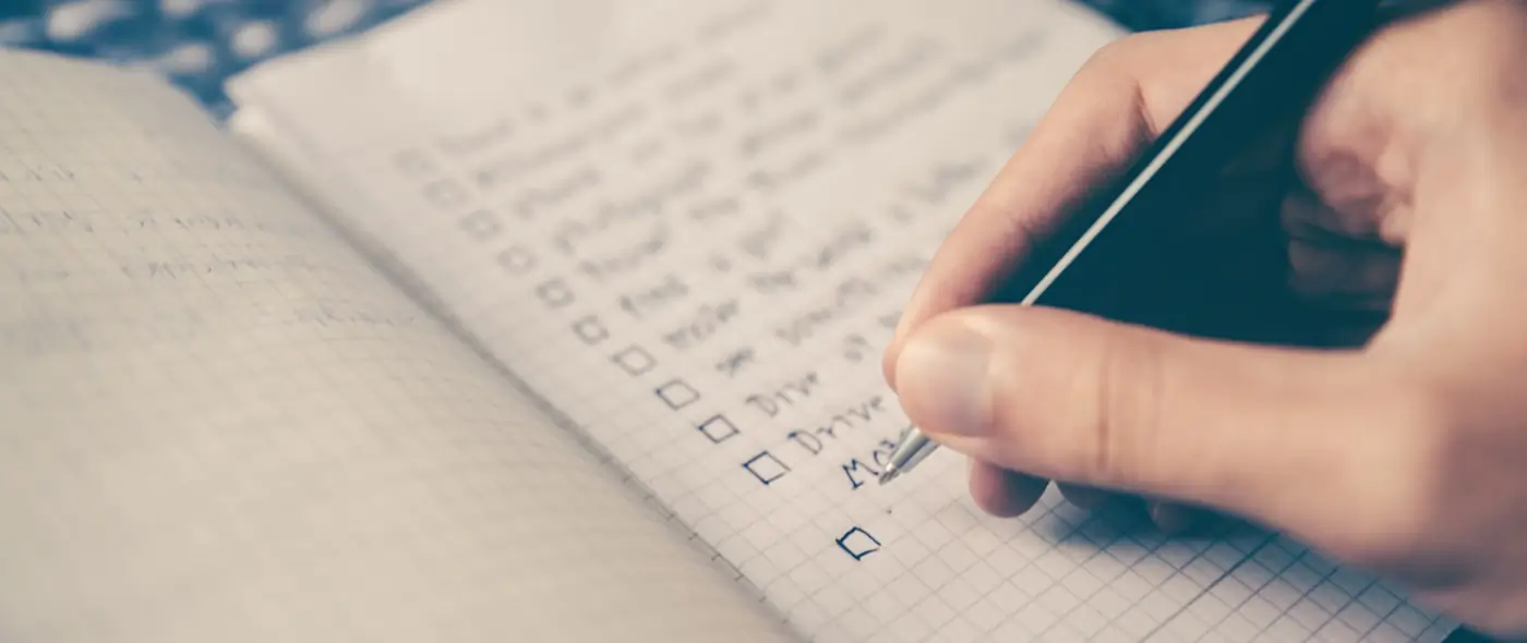Notepad with checklist and pen on a clean desk