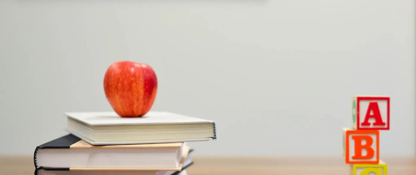 Apple and books on a desk suggesting learning and study