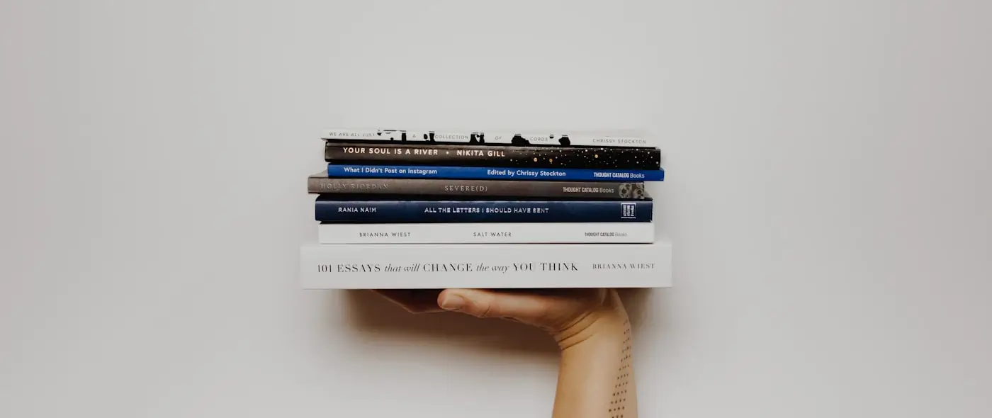 Stack of books and eyeglasses on a wooden table